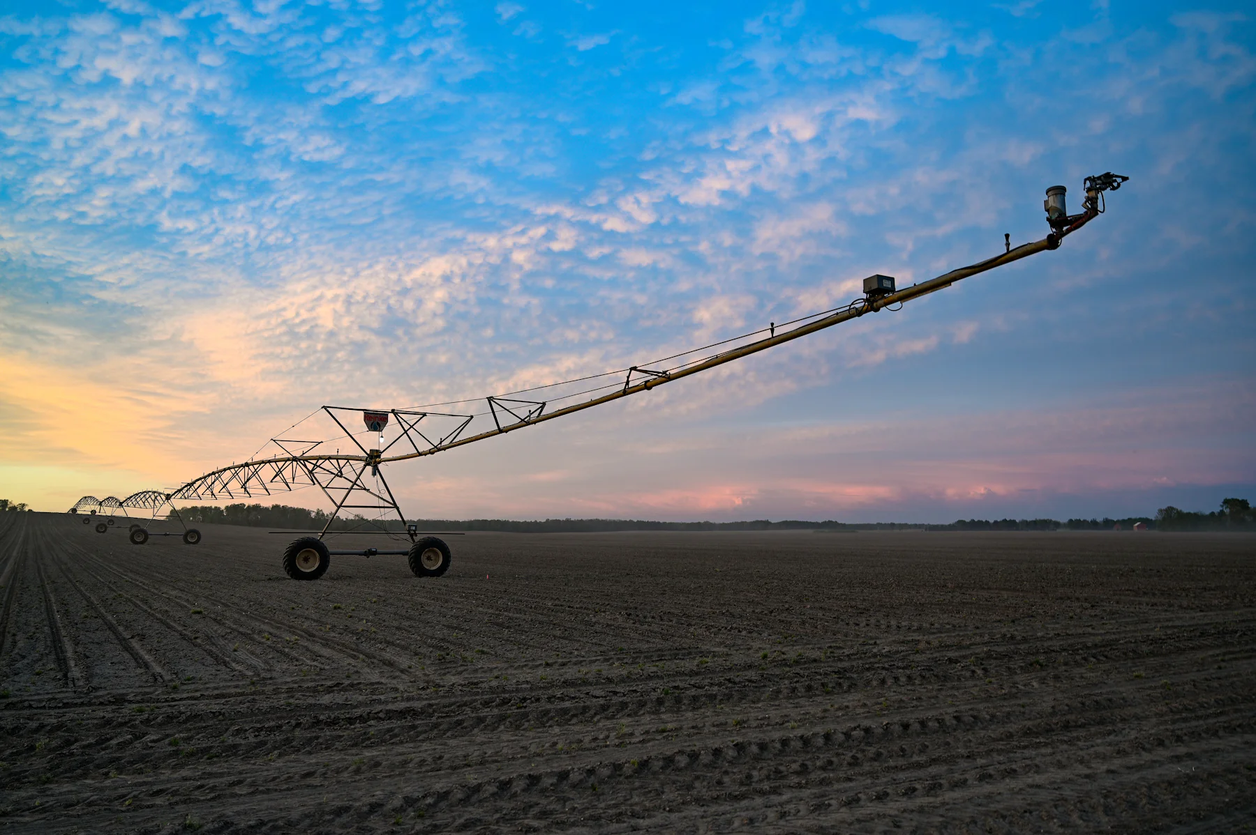 Pivô central de irrigação sobre uma lavoura ao amanhecer